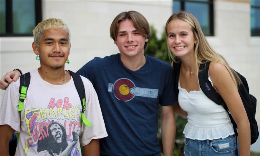 Three people smile